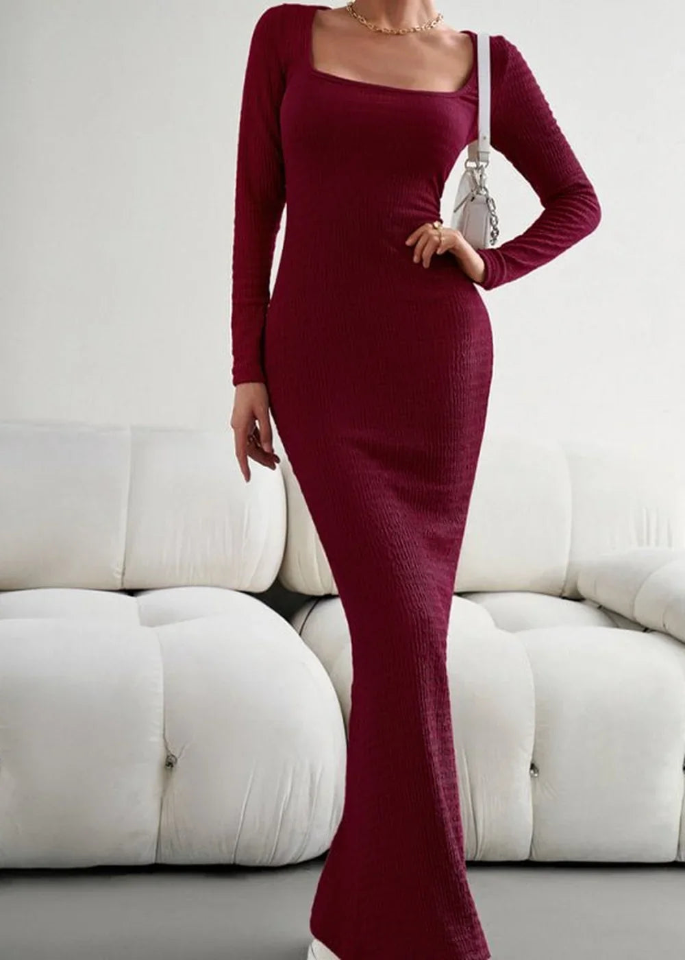 Maroon ribbed long-sleeve maxi dress with a square neckline, fitted silhouette, and white crossbody bag.