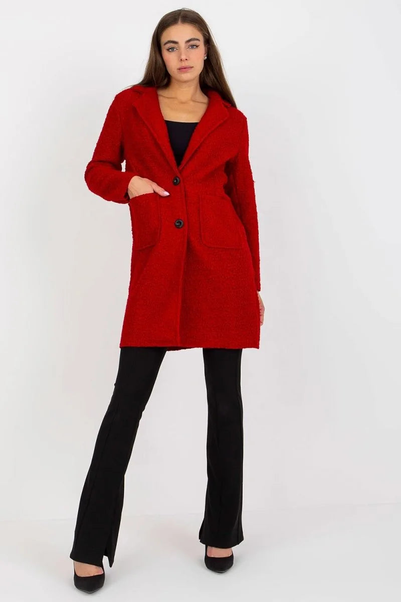 Red textured coat with black buttons and black flared pants on a model.
