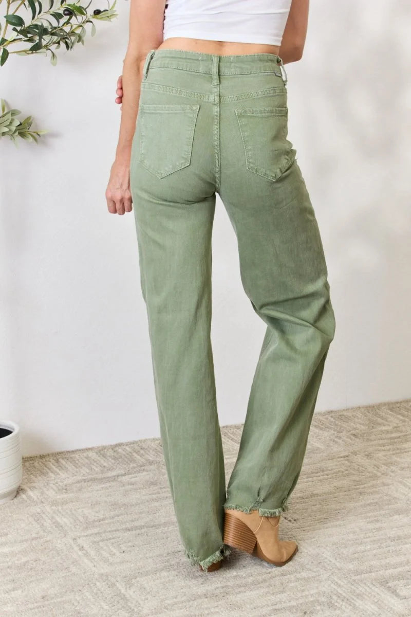 Close-up of the raw hem detail on sage jeans