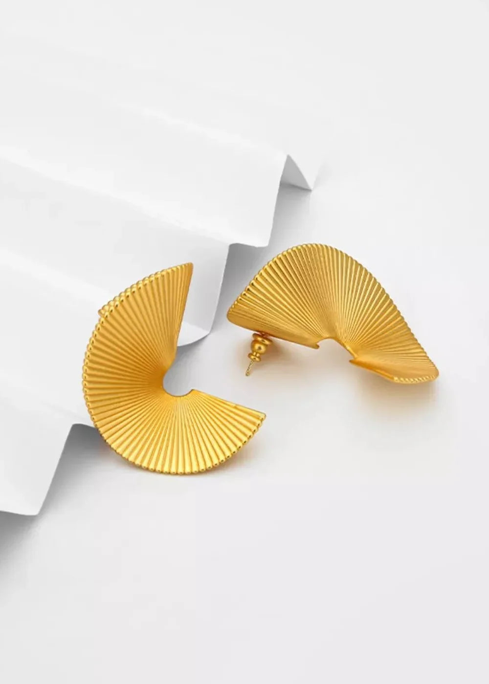 Gold-plated fan-shaped earrings with ribbed texture on a white background