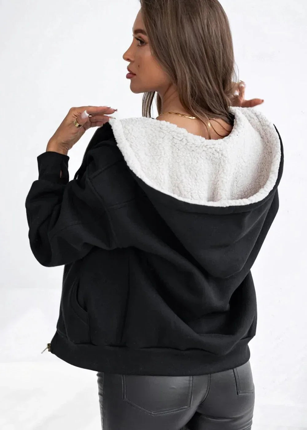 Black sherpa-lined zip-up hoodie with soft texture, shown from the back on a model.