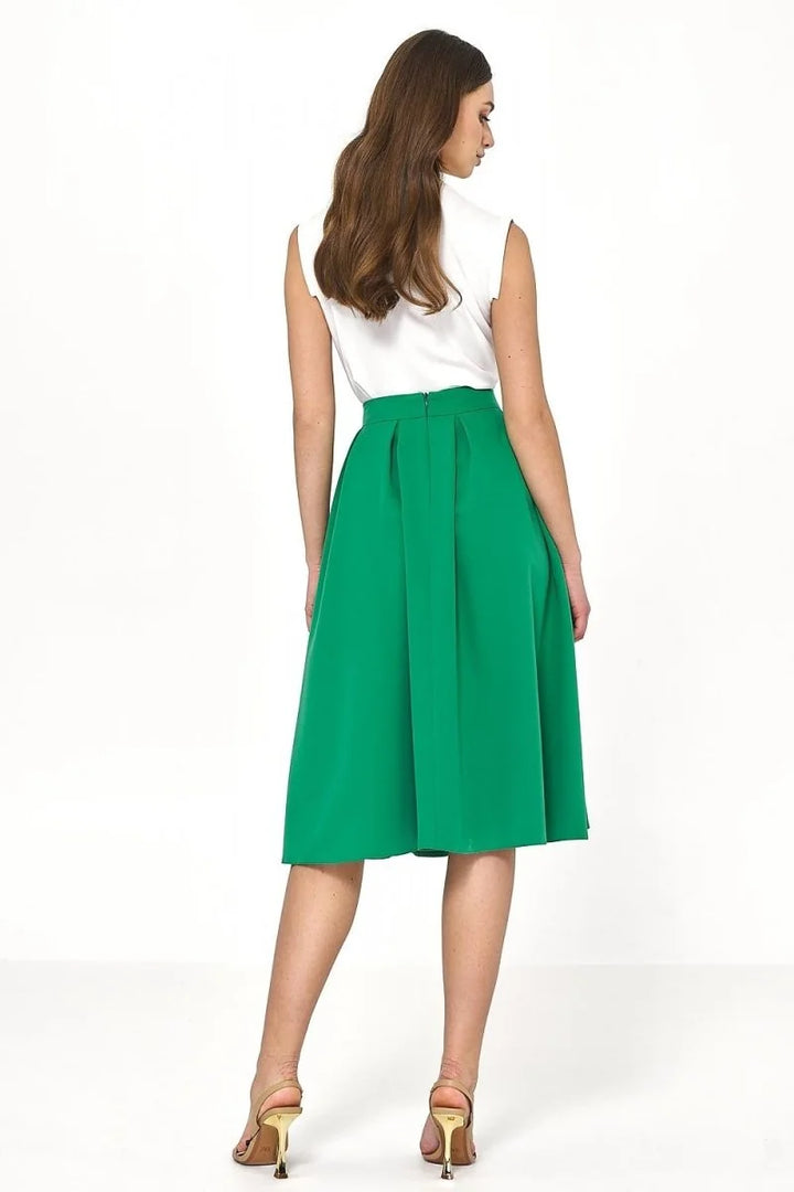 Emerald green midi skirt with box pleats, shown from the back on a model wearing gold heels.