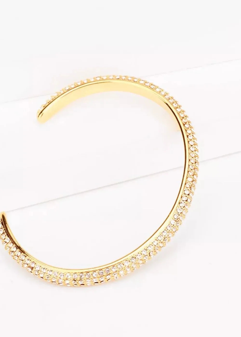 Gold-plated cuff bracelet with two rows of sparkling white cubic zirconia stones.