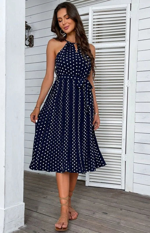 Model wearing a blue polka dot halter neck midi dress
