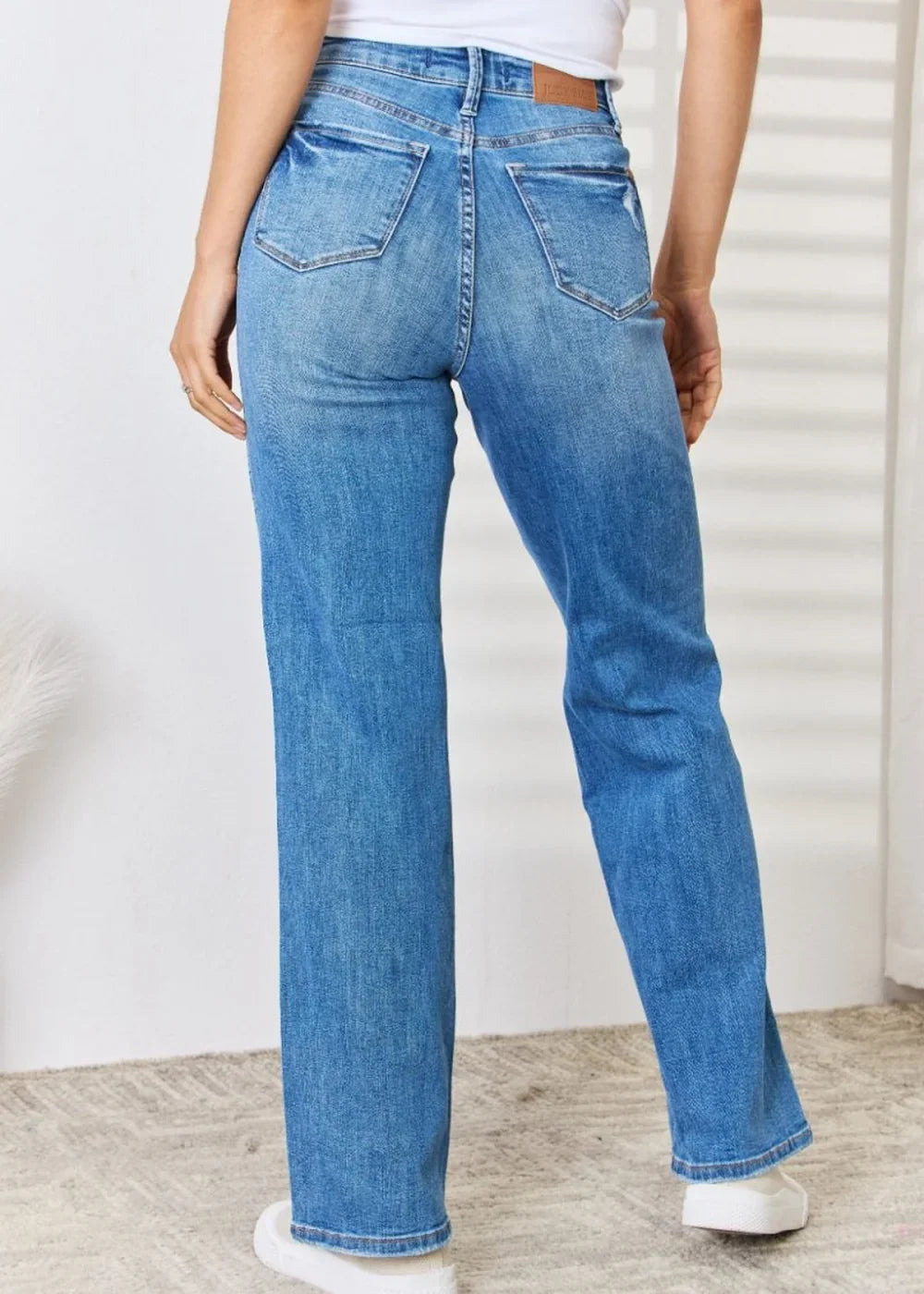 Close-up of distressed detailing on straight-leg jeans