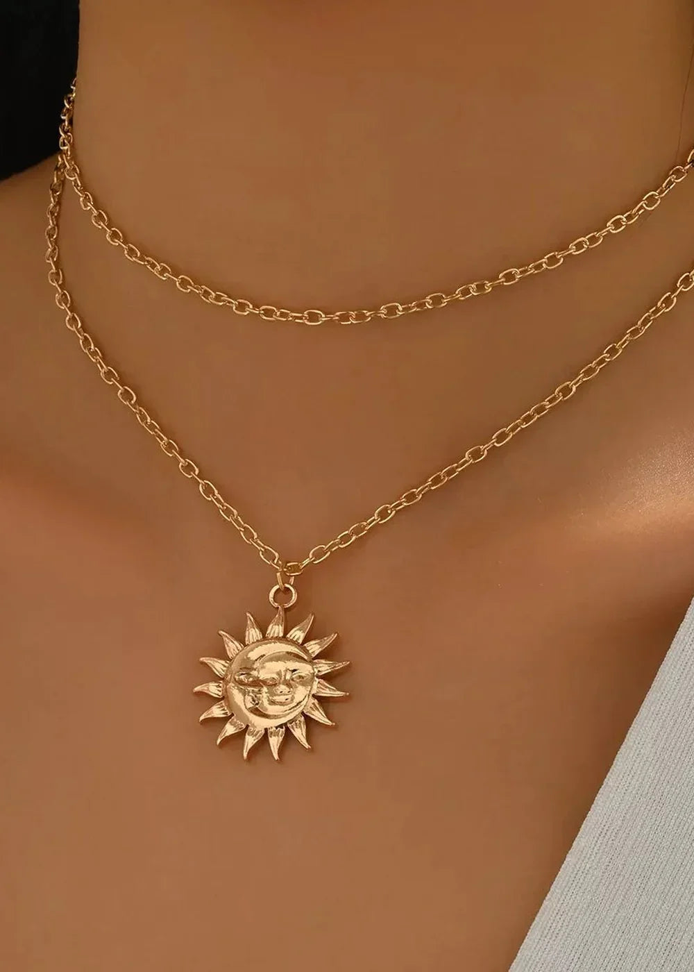Close-up of the sunburst pendant on a gold chain