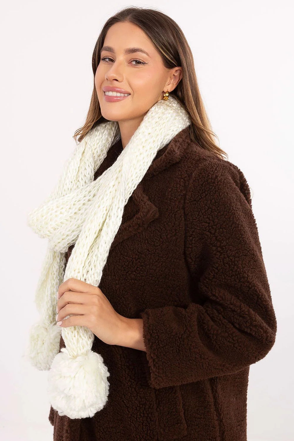 Close-up of pompons on a beige scarf