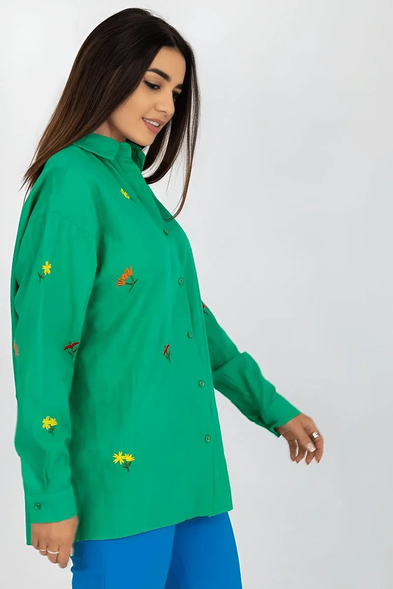 Close-up of embroidered flowers on green shirt