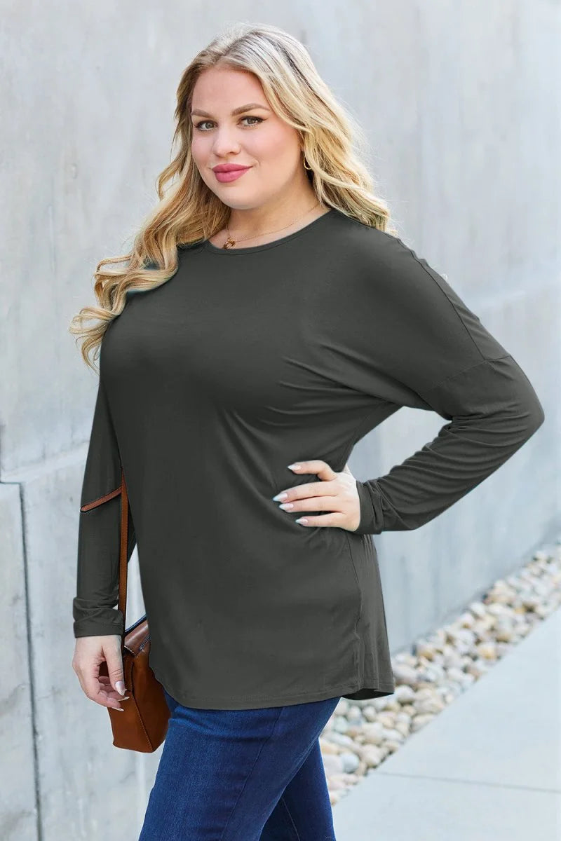 Dark gray long-sleeve top with a relaxed fit, worn by a model with blonde hair.