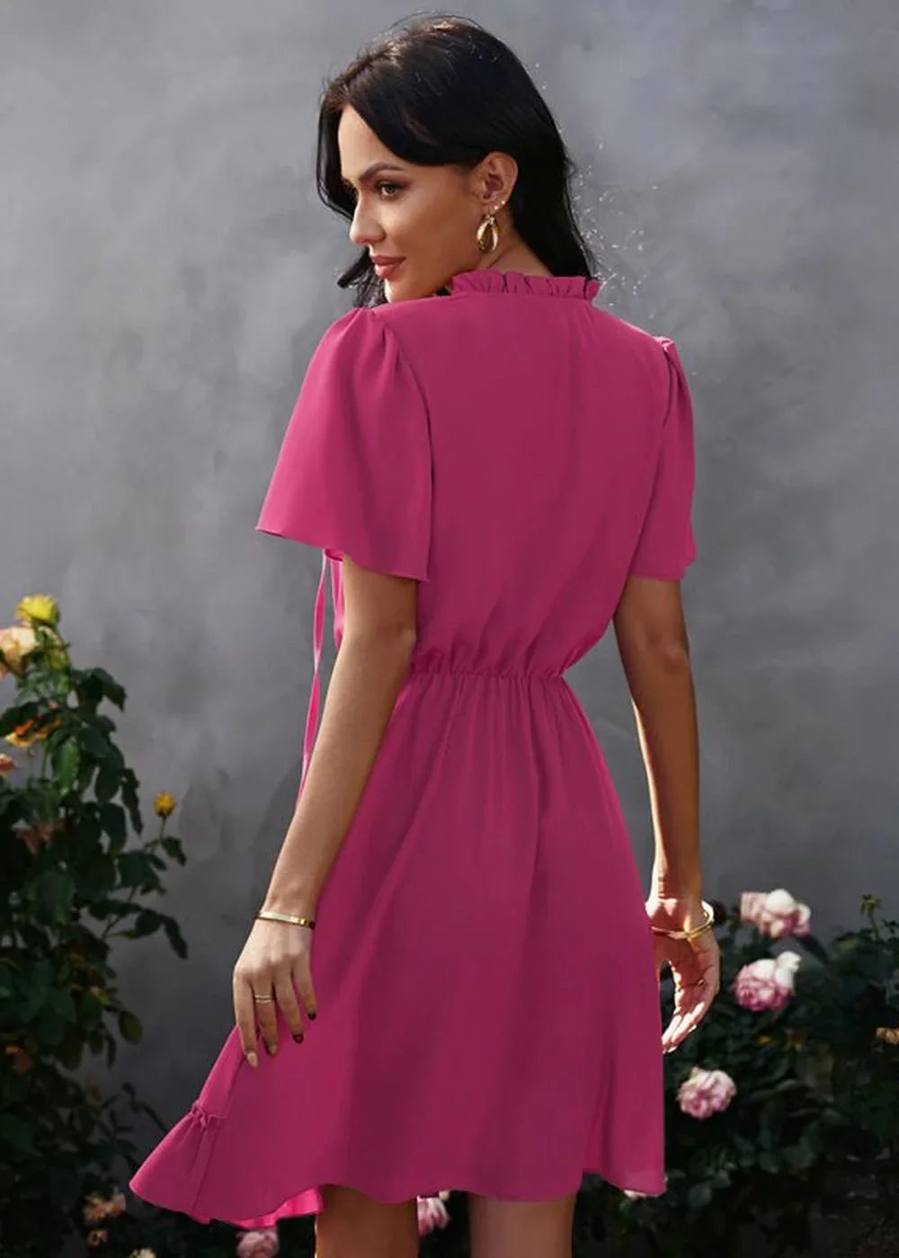 Fuchsia polyester dress with ruffled neckline and flutter sleeves, cinched waist, and ruffled hem.