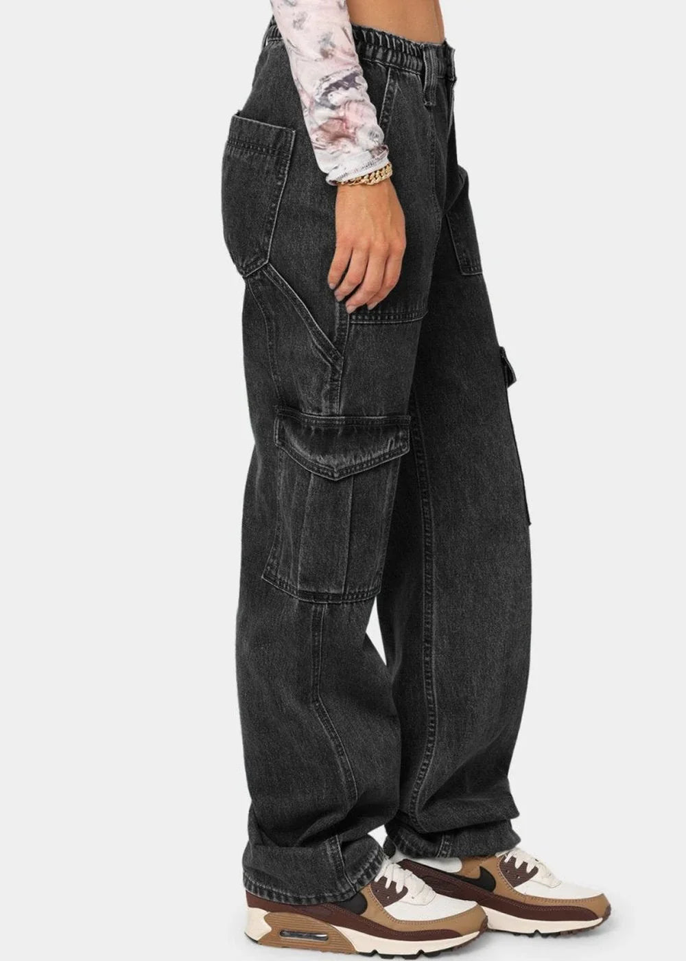 Black denim cargo pants with multiple pockets and a relaxed fit, paired with tan and white sneakers.