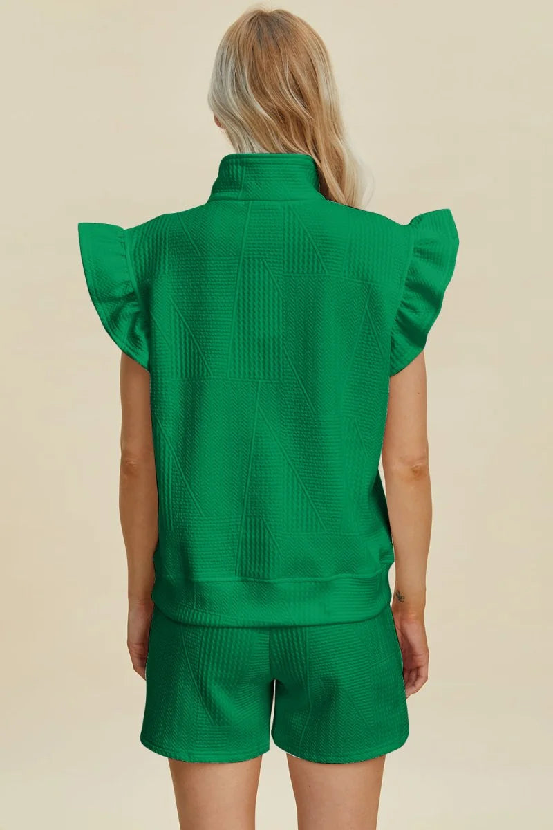 Back view of a green textured short suit with ruffled cap sleeves.