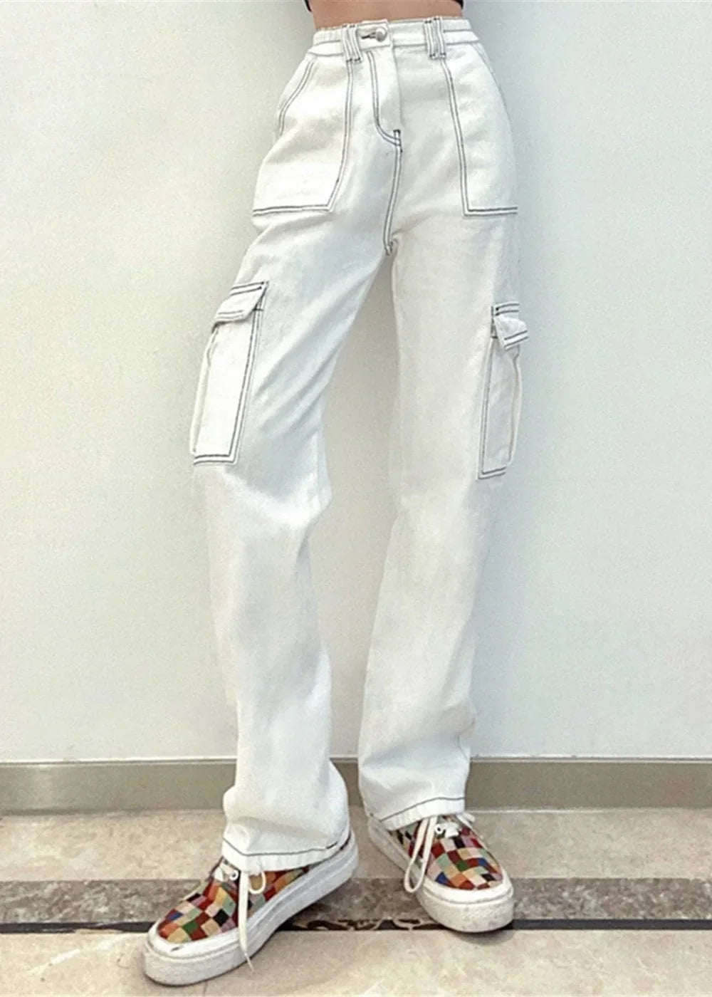 White cargo pants with contrasting stitching and a regular fit, paired with colorful checkered platform sneakers.