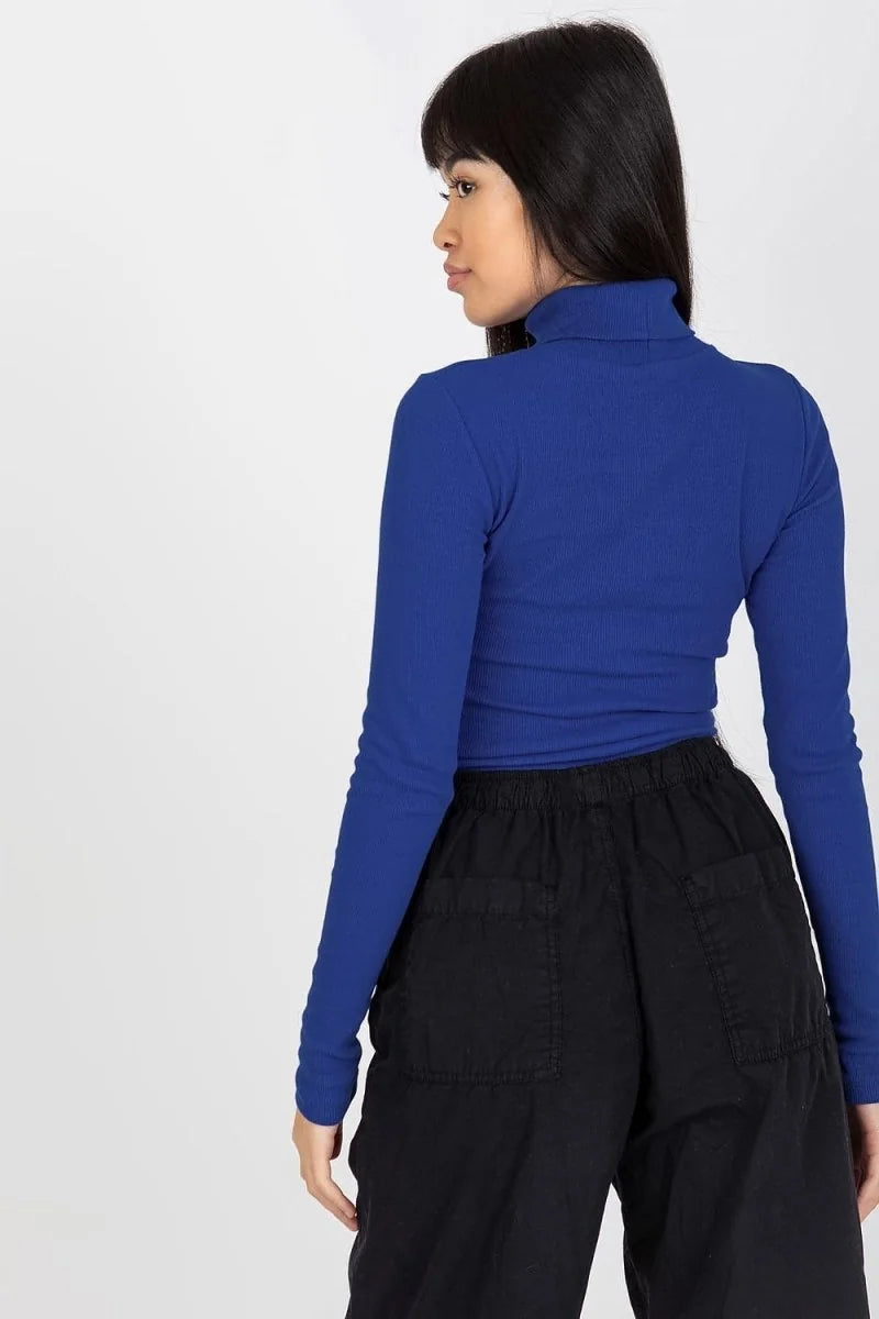 Royal blue ribbed turtleneck crop top with black cargo pants.