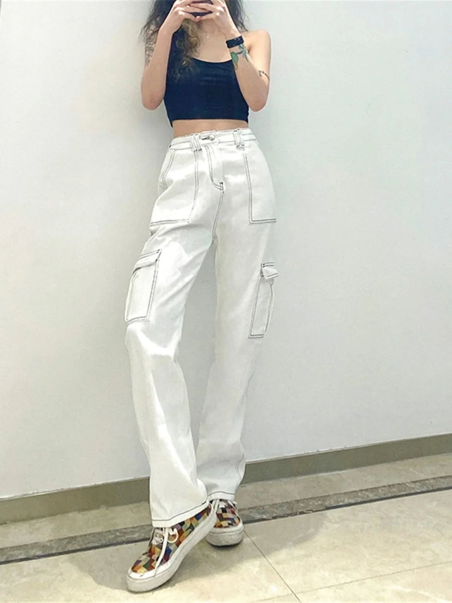 White cargo pants with contrast stitching and colorful patchwork sneakers on model.