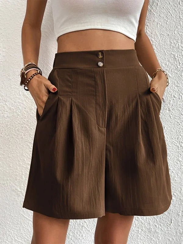 Brown pleated shorts with button detail and pockets on model