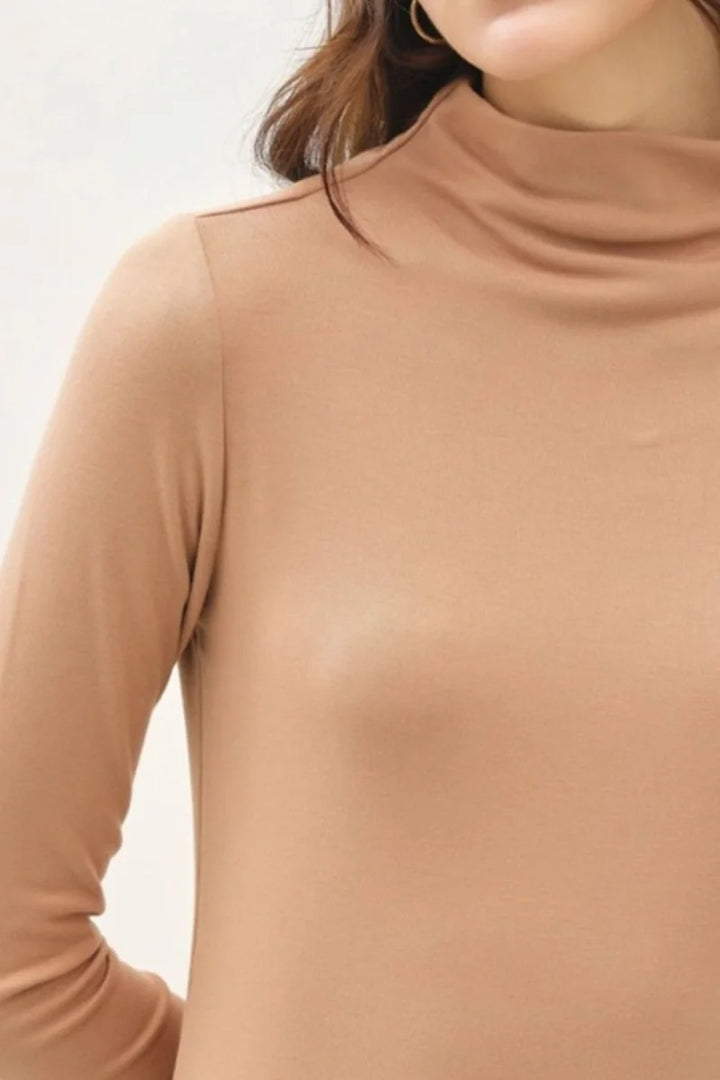 Close-up of a camel-colored, long-sleeved turtleneck top made of a soft, stretchy knit fabric.