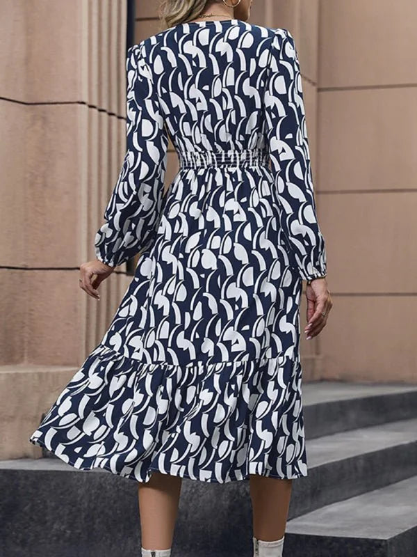 Navy blue and white abstract print midi dress with long sleeves and ruffled hem.