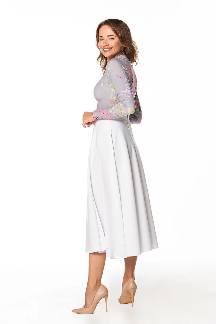 White A-line midi skirt with a smooth texture, paired with nude pointed-toe heels.
