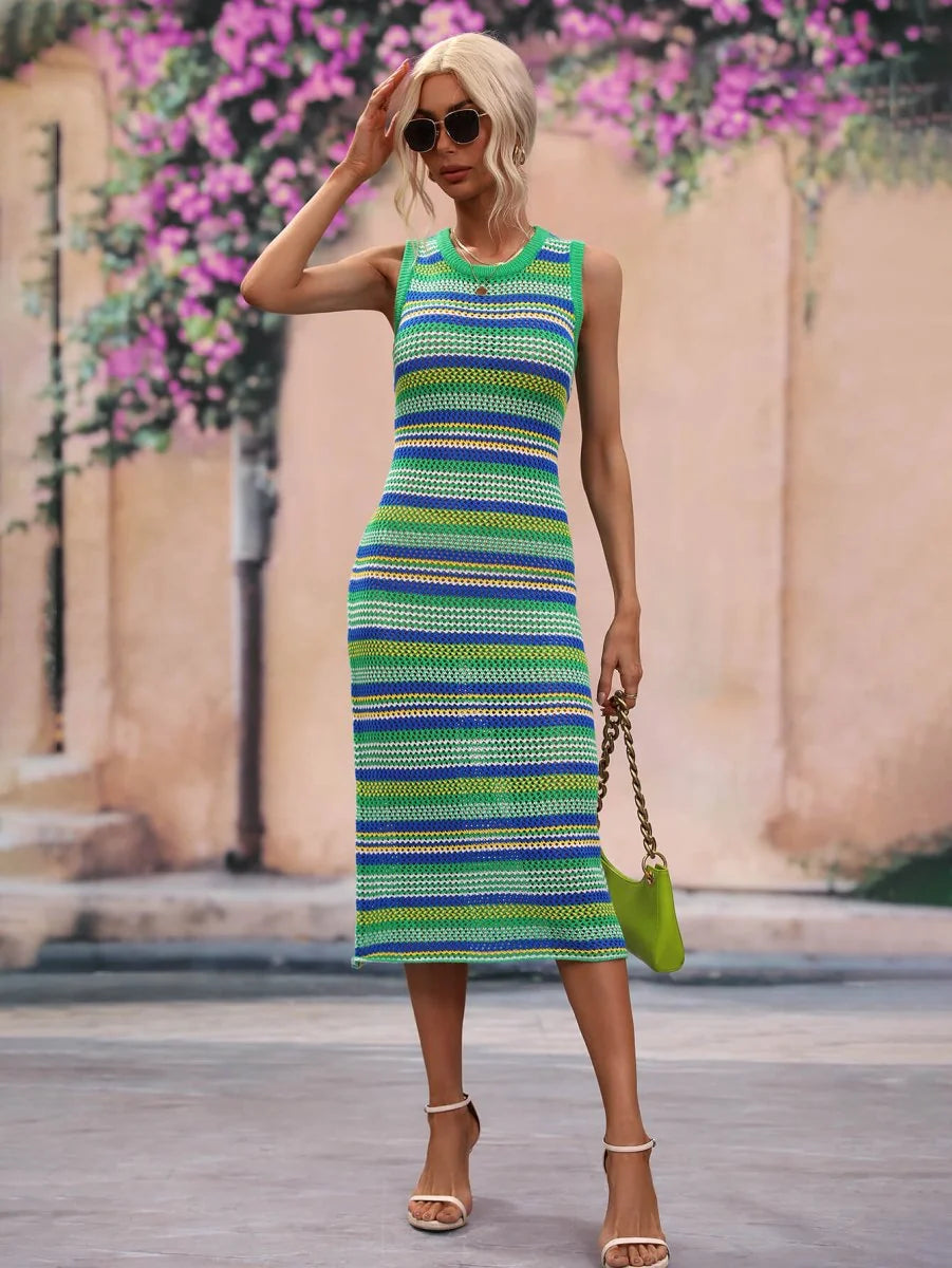 Woman in a sleeveless, striped knit midi dress in green, blue, and yellow, holding a lime green handbag.