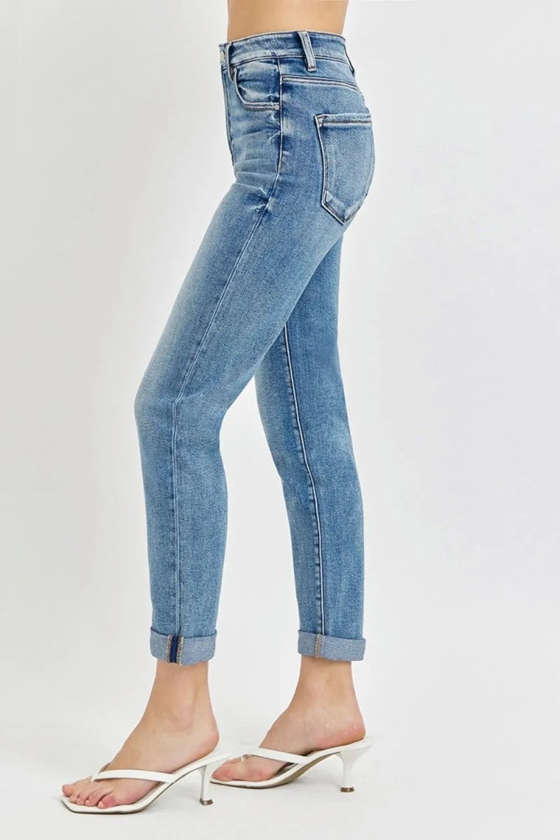 Light wash high-rise jeans with a slight stretch, cuffed ankles, and white thong sandals.