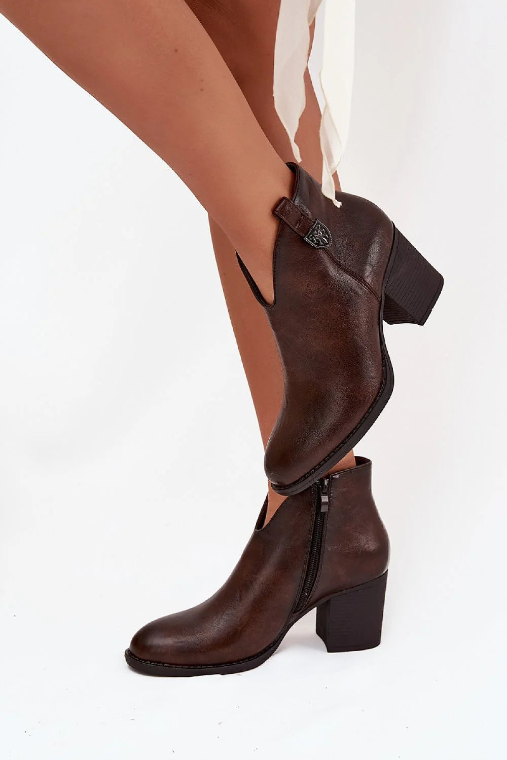 Brown leather ankle boots with side zipper and block heel, on model.
