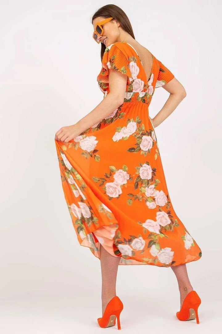 Orange floral print maxi dress with cinched waist and ruffled sleeves, worn with orange heels.