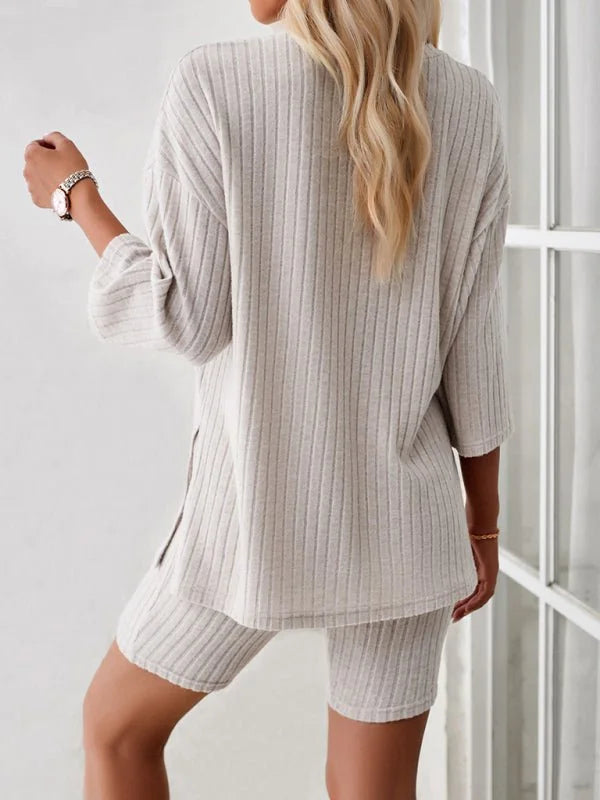 Light beige ribbed knit short suit with a relaxed-fit top and biker shorts, shown from the back on a model.
