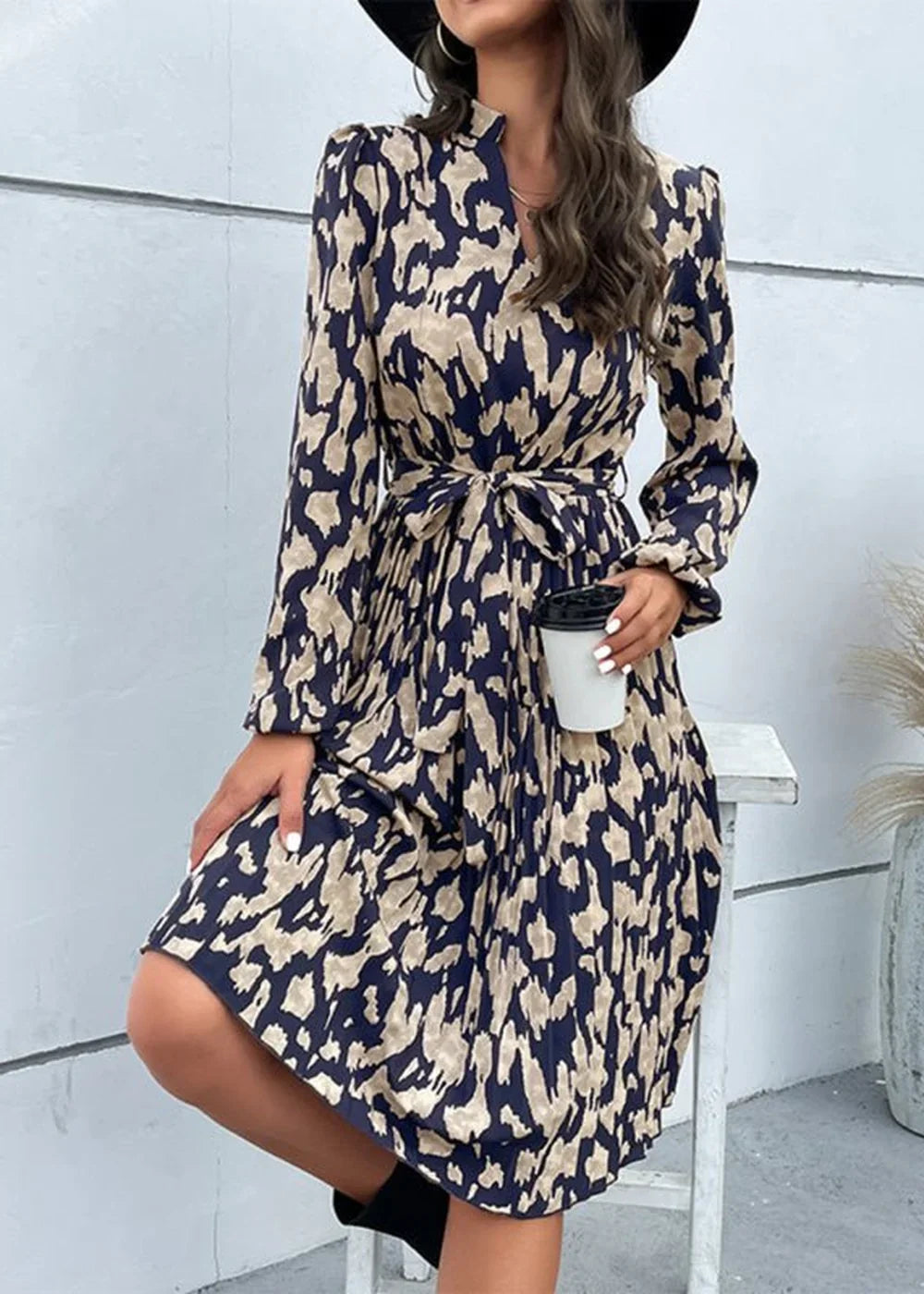 Navy blue and tan abstract print midi dress with tie waist and long sleeves.