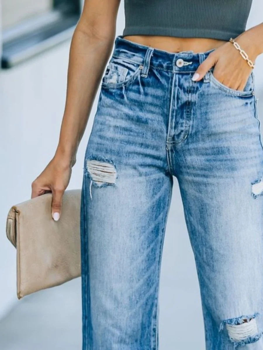 Light wash distressed denim jeans with ripped details and a straight leg fit.