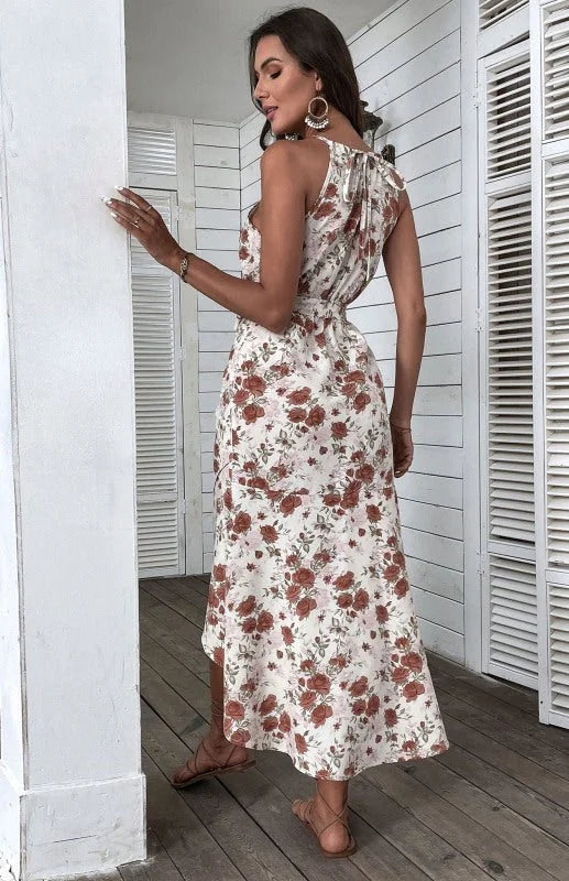 Woman in a floral maxi dress with rust-colored roses and brown sandals, shown from the back.