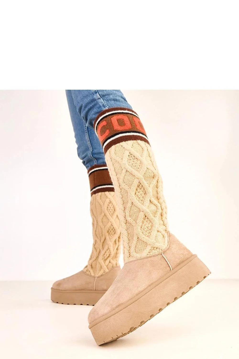 Beige knit boots with cable knit texture and faux suede trim, featuring colorful "CDG" lettering.