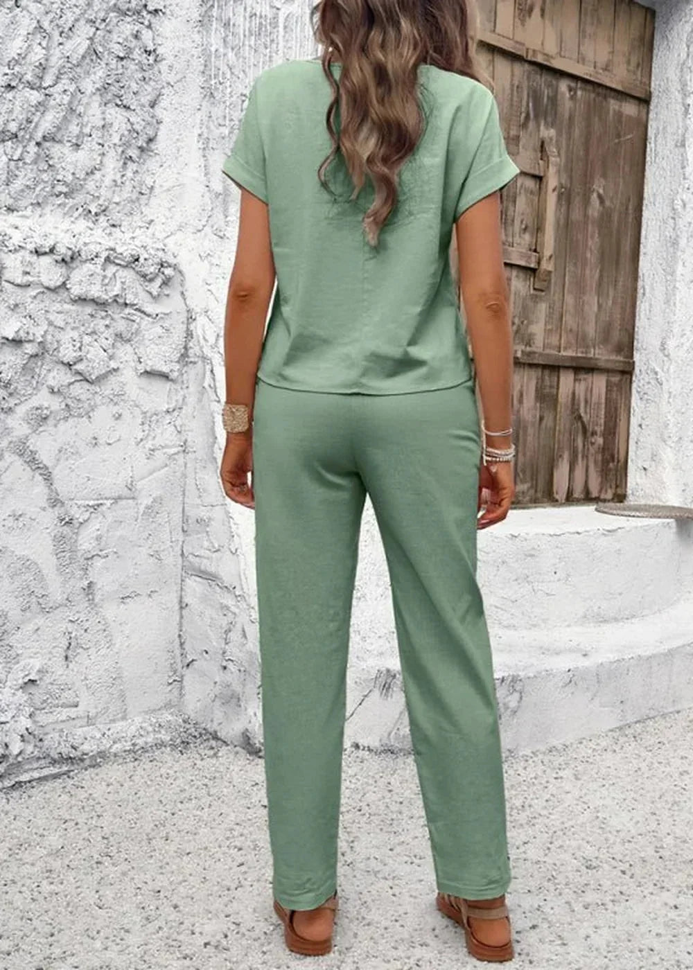 Sage green linen-blend pant suit with short sleeves, wide-leg pants, and sandals shown from the back.