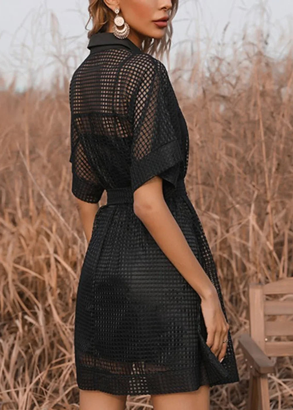 Black mesh dress with a collar and short sleeves, cinched waist, and a checkered pattern.