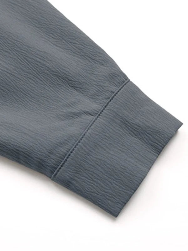 Close-up of a grey textured sleeve cuff with visible stitching.