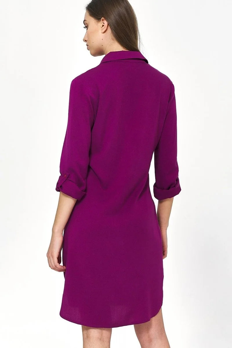 Back view of an oversized fit, plum-colored viscose shirt dress with rolled-up sleeves.