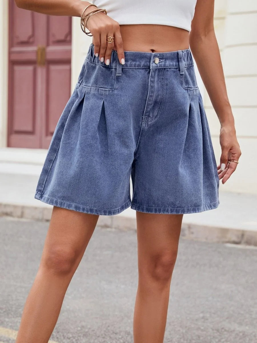 Blue denim shorts with a high waist, pleated front, and a relaxed, wide-leg fit.