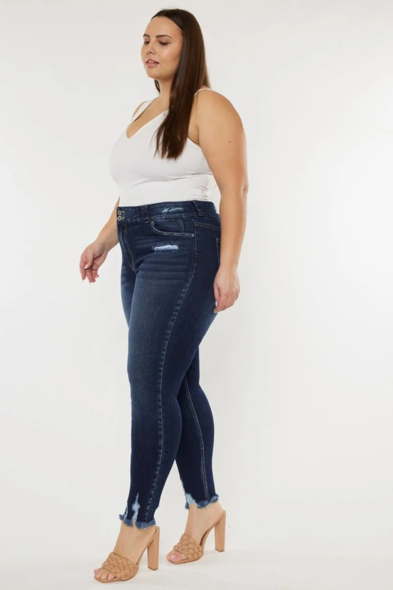 Dark wash denim skinny jeans with distressed details and frayed hem on model.