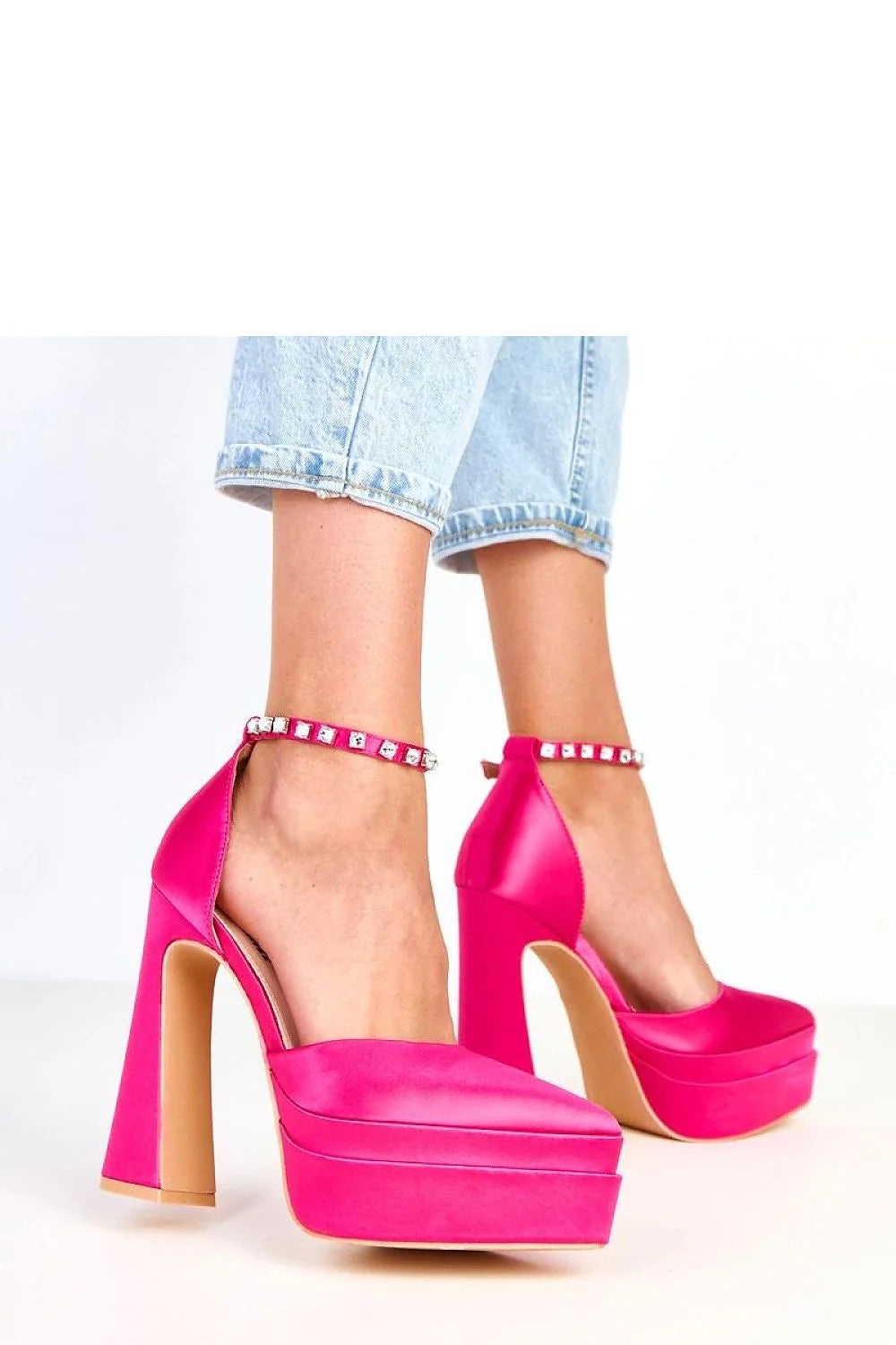 Hot pink satin platform heels with jeweled ankle straps on a model.