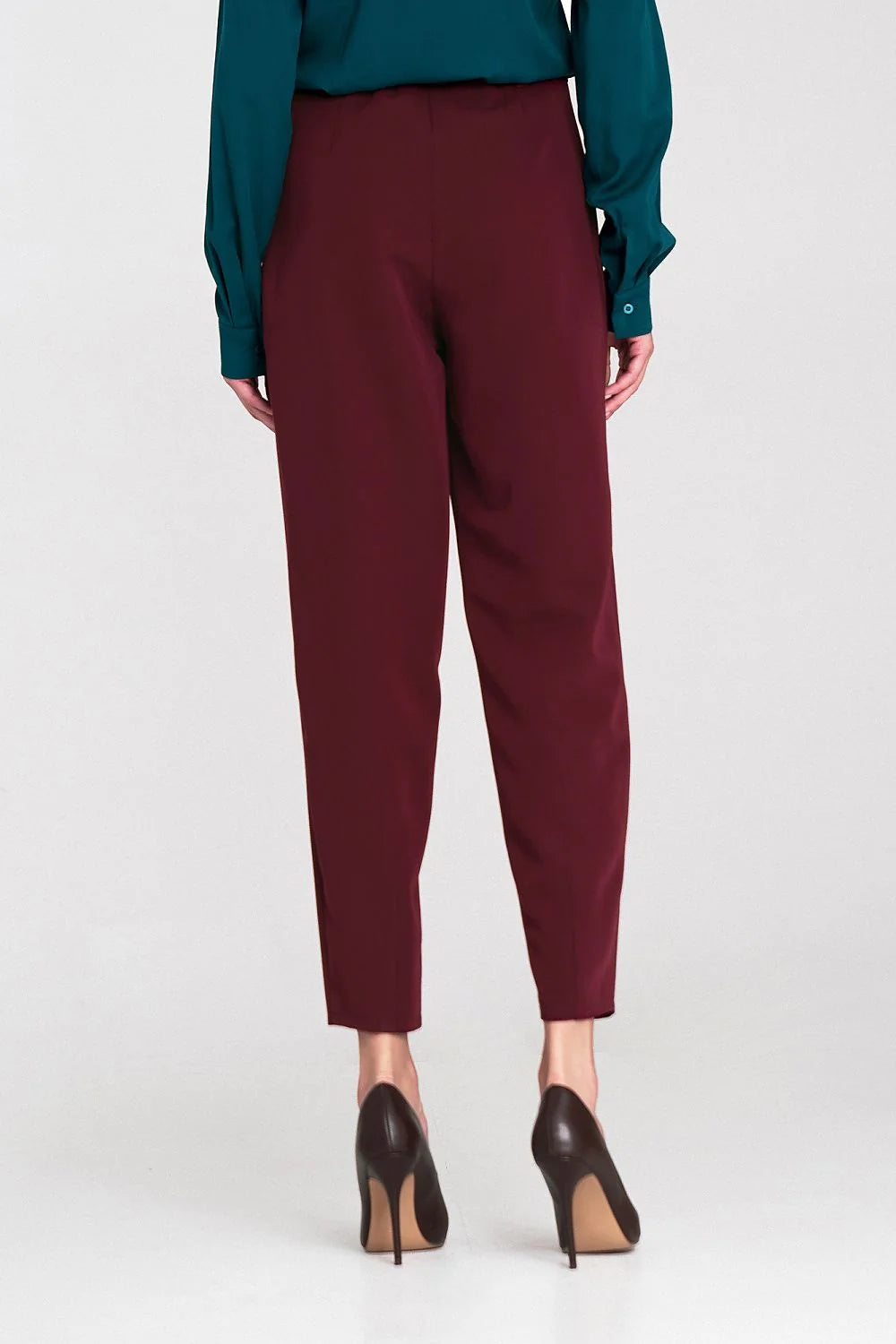 High-waisted, oversized maroon pants with a tapered leg, shown from the back on a model wearing black heels.