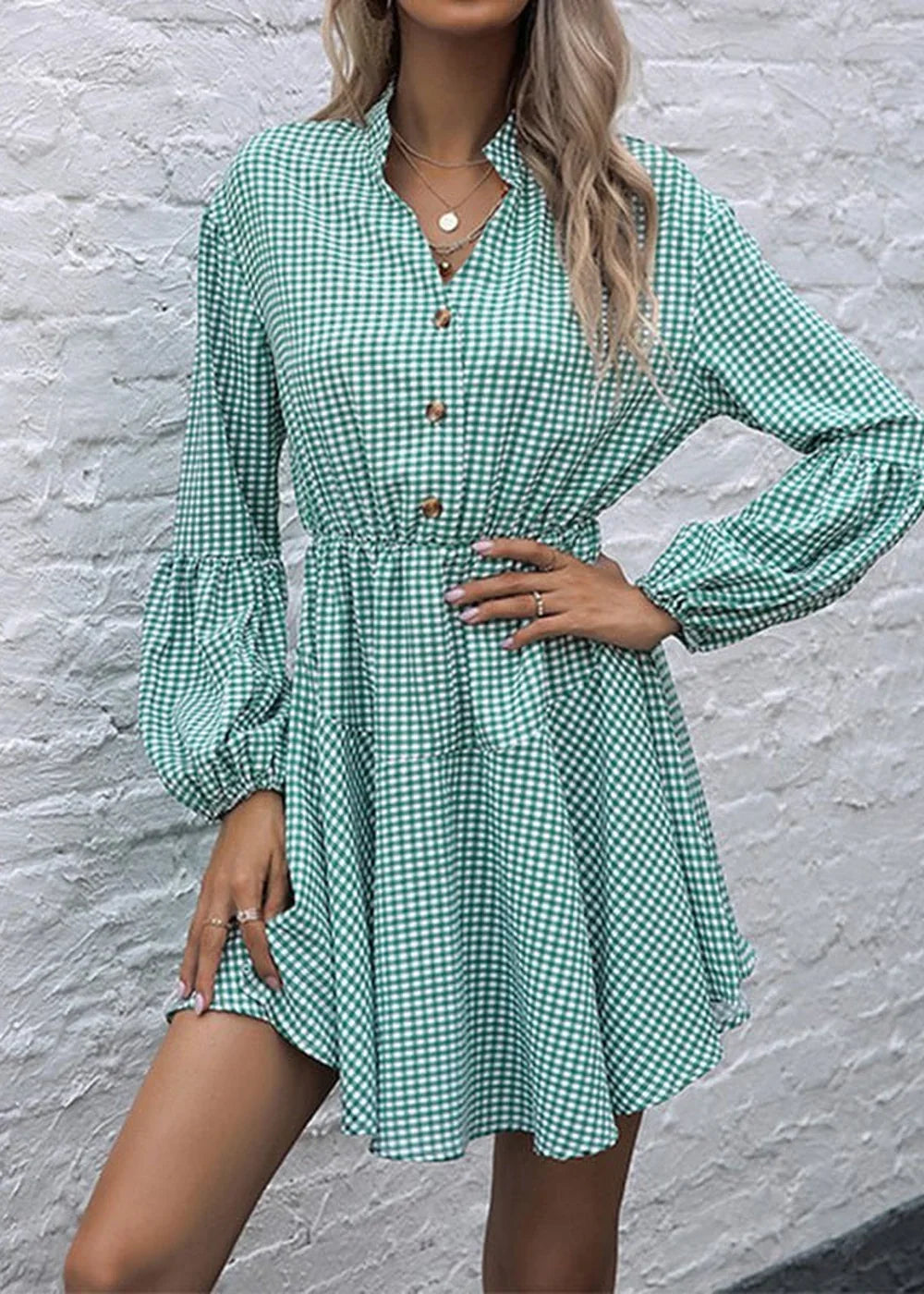 Green and white gingham print dress with button front and billowy sleeves on model.