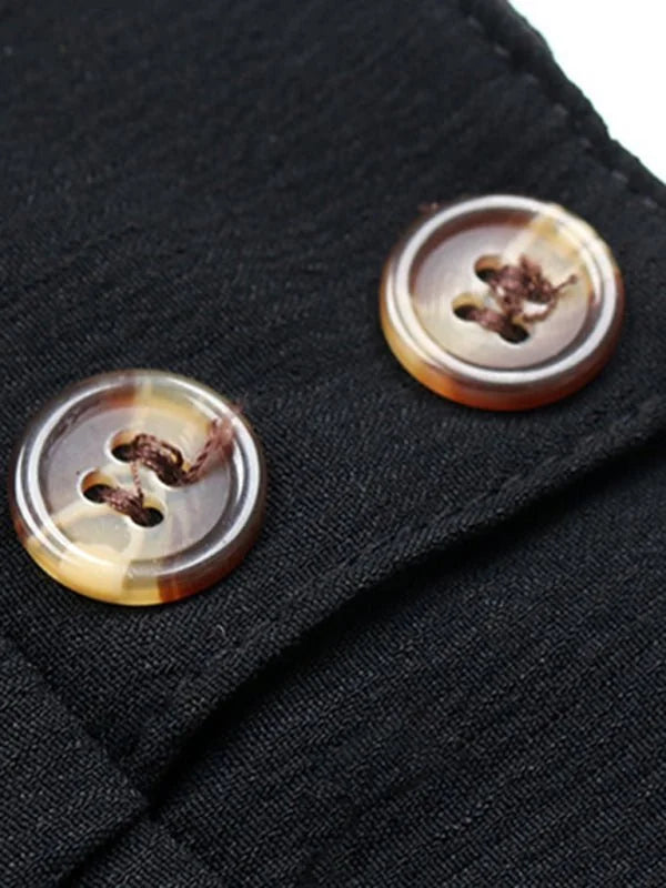 Close-up of black fabric with two marbled brown buttons and visible stitching.