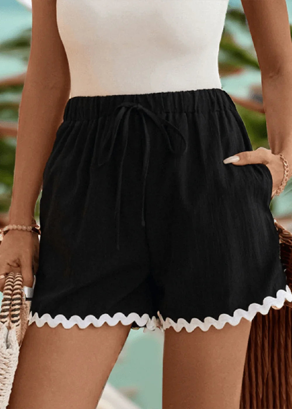 Black shorts with white scalloped trim, drawstring waist, and pockets on model.