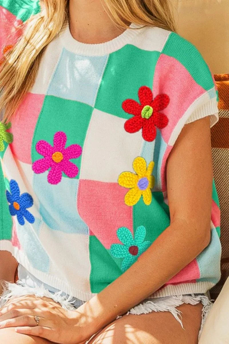 Cropped checkered knit top with colorful crochet flowers in pink, blue, red, yellow, and teal.