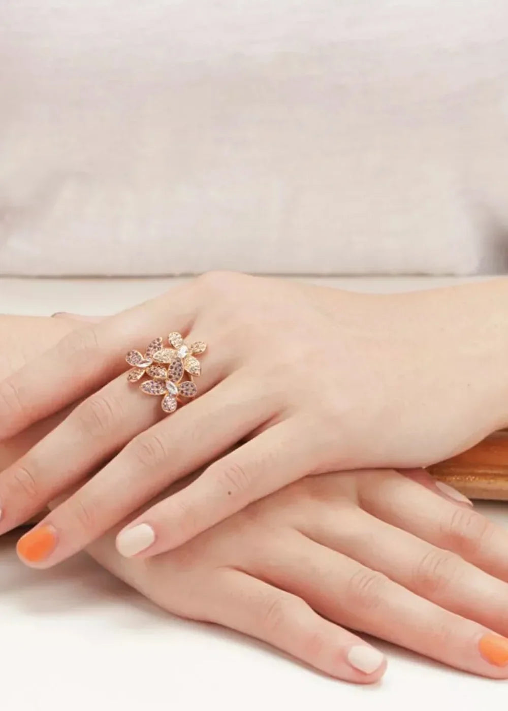 Gold-plated ring with a cluster of sparkling rhinestones and zircon flowers on a woman's hand.