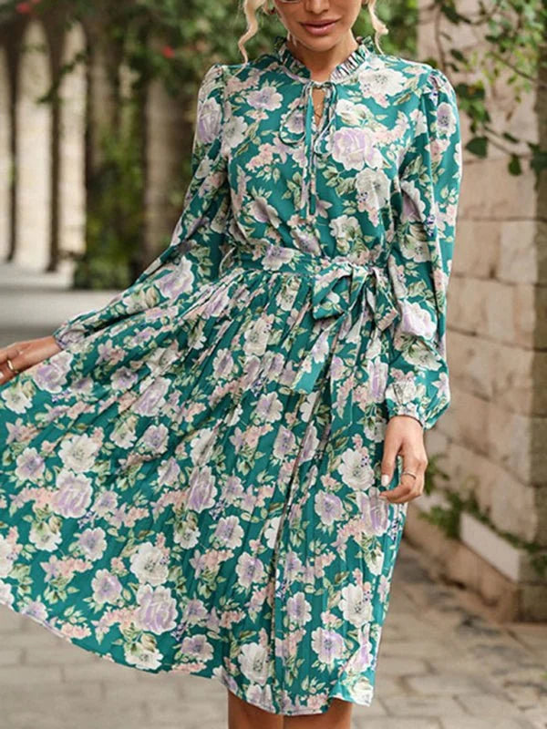 Green floral print dress with long sleeves, tie neck, and belted waist.