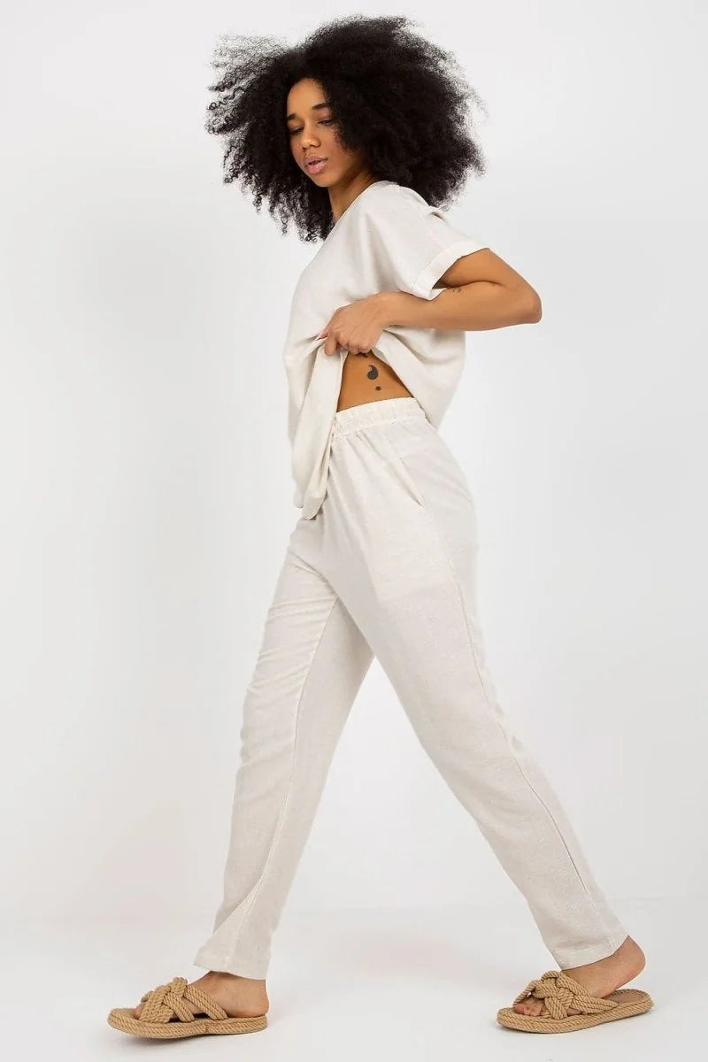 Cream linen-blend pants with a drawstring waist, shown on a model with natural texture.