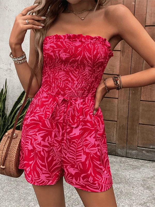 Red and pink leaf print strapless jumpsuit with ruffled top and tie waist.