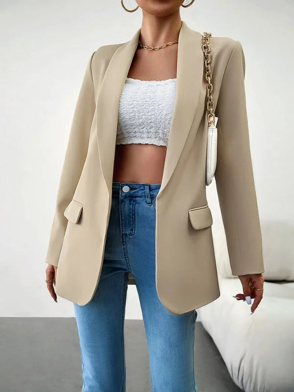Model wearing a beige blazer, white textured crop top, and light wash jeans.