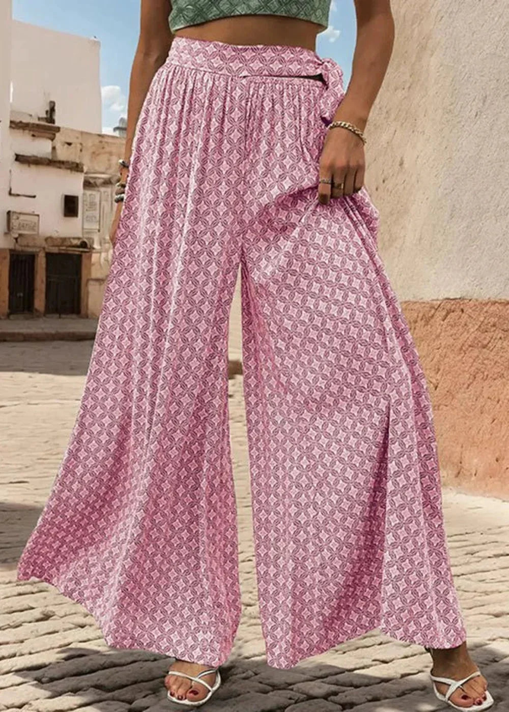 Pink wide-leg pants with geometric pattern and tie waist detail.